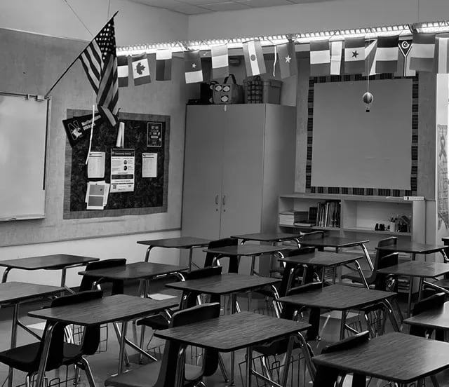 An empty classroom, desks and flags